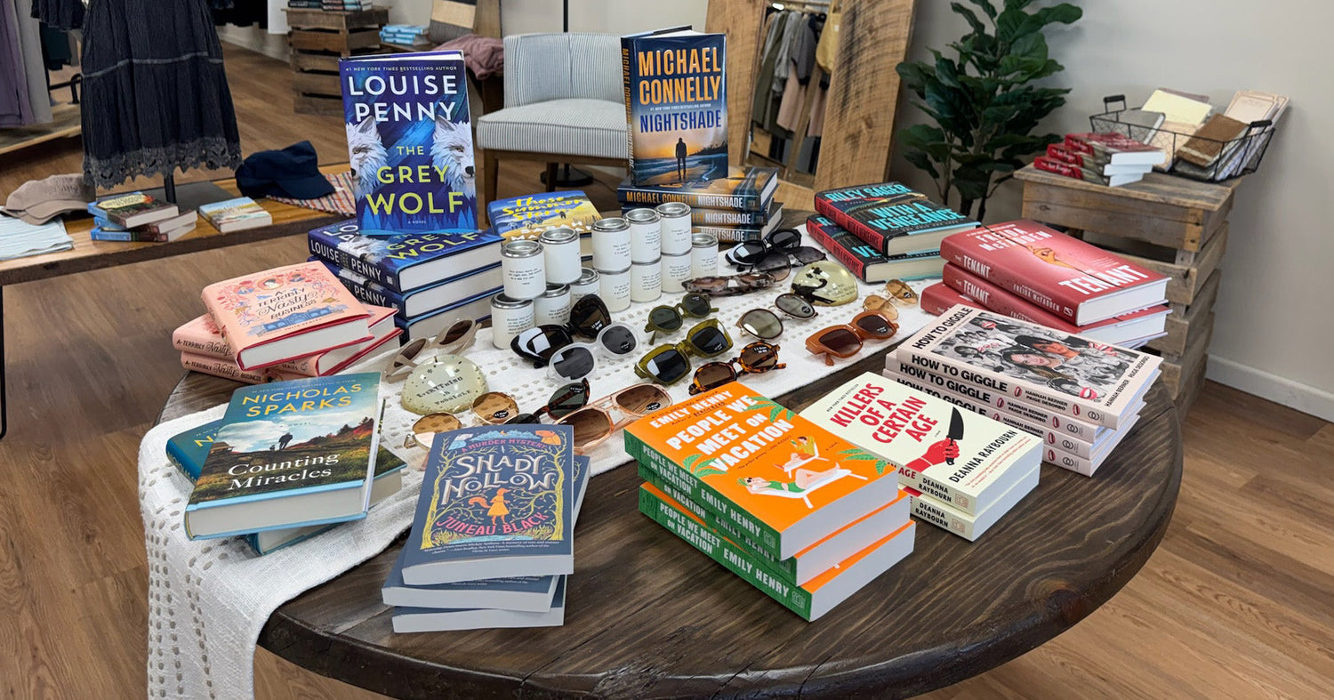 A wooden table with books and sunglasses for sale